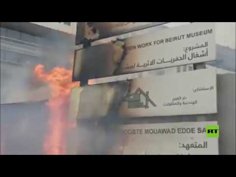 شاهد محتجون يضرمون النار باللوحات الإعلانية في ساحة الشهداء وسط بيروت