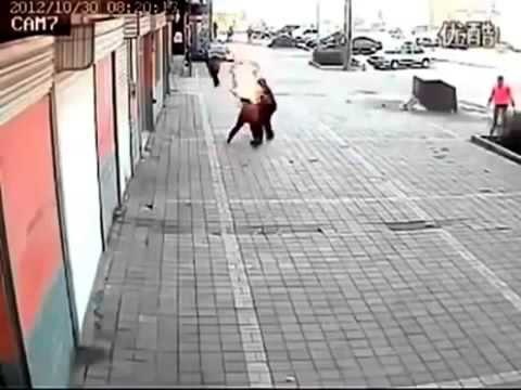 رجل يحرق زوجته في الشارع وأصحاب المحلات يحاولون إطفاءها